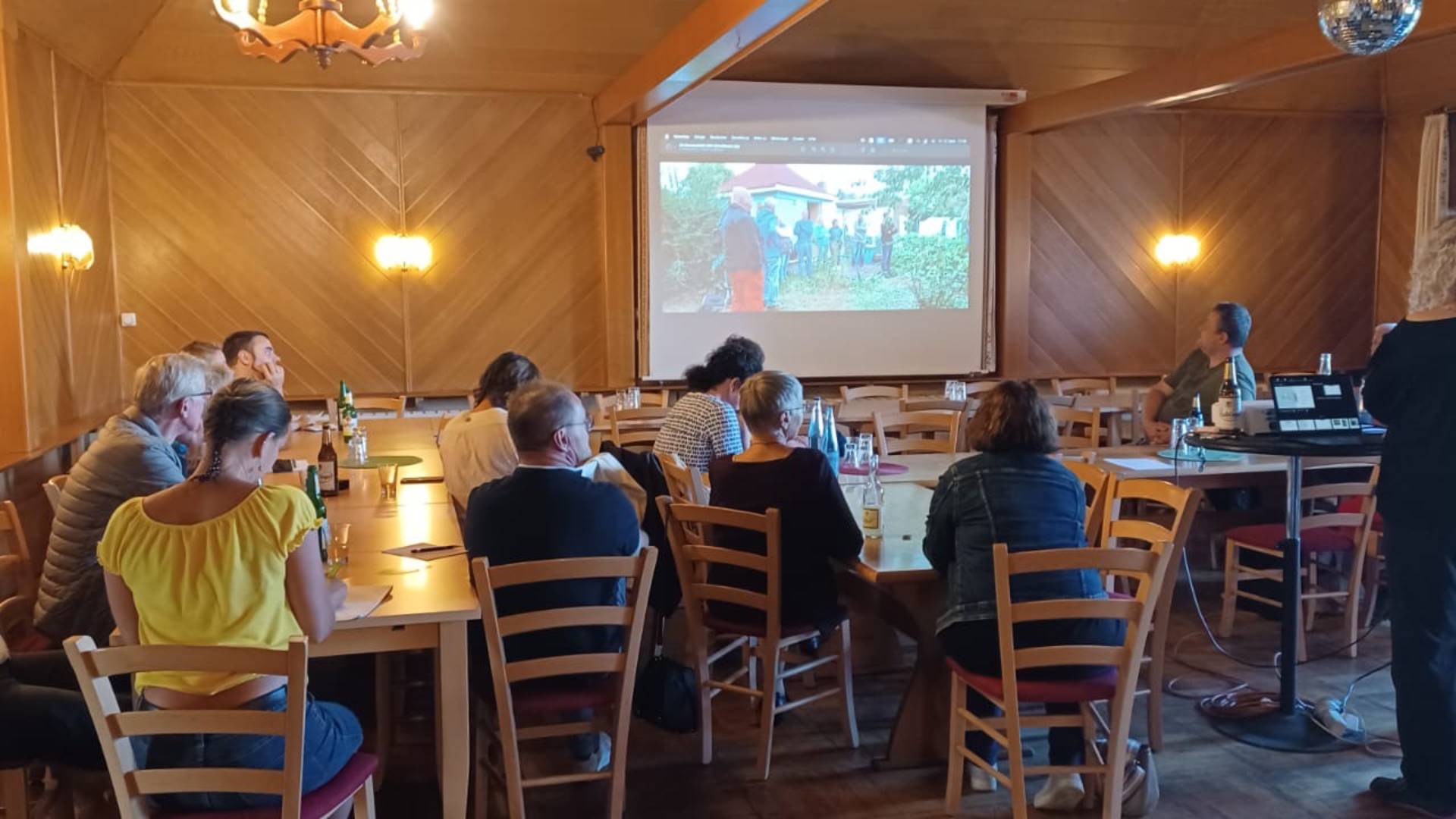 Menschen in einem Saal, die einem Vortrag lauschen