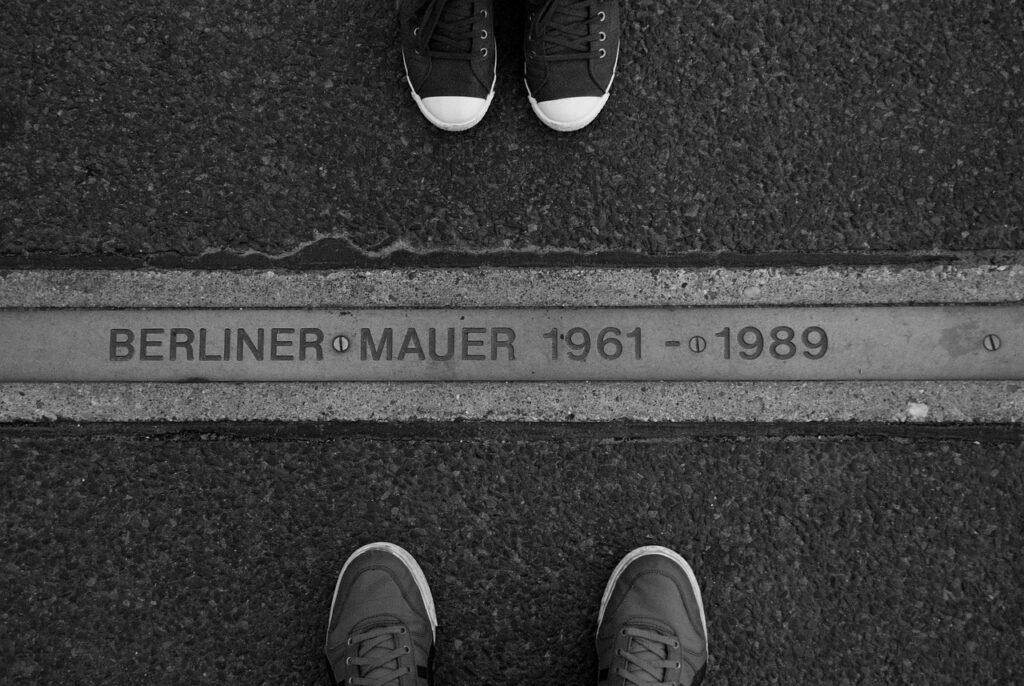 Der Schriftzug "Berliner Mauer 1961-1989" oben drüber und unten drunter ein Paar Füße.